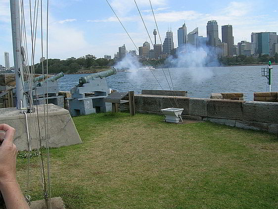 The One O'clock Gun fires from Fort Denison with a view of Sydney in the background