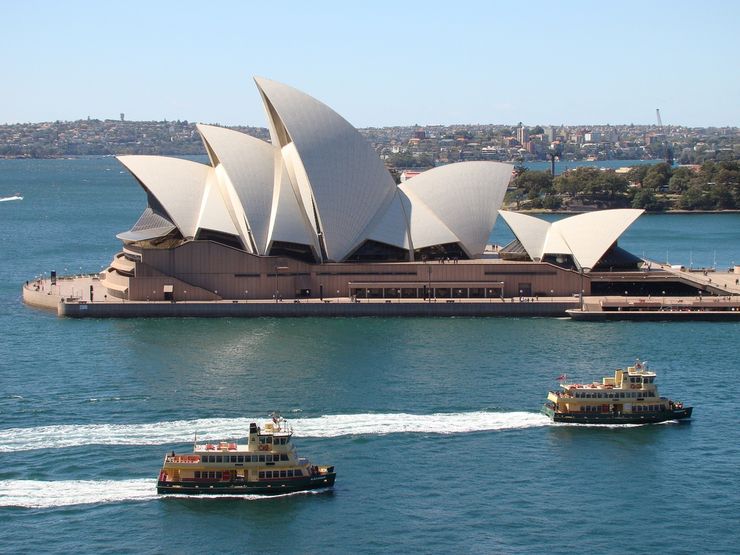 Two Sydney Ferries pass the Sydney Opera House as they approach Circular Quay