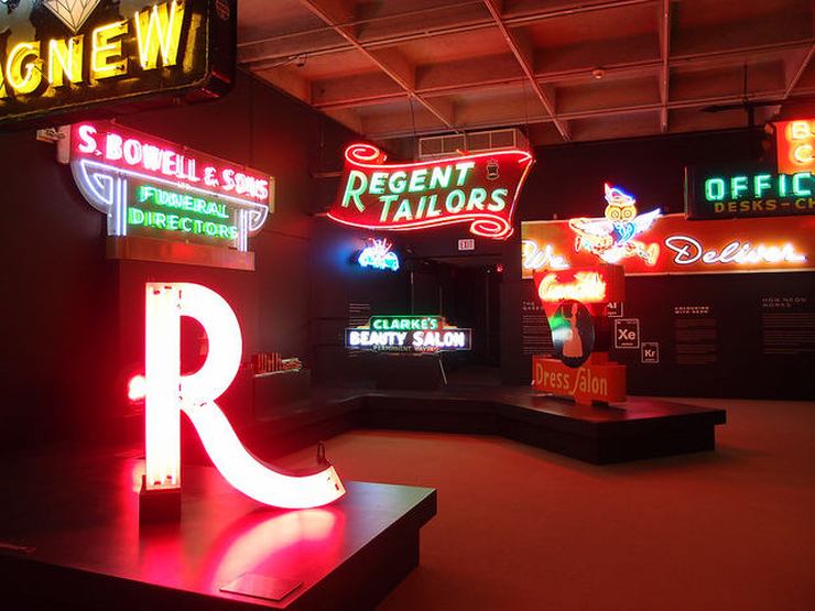A display of brightly lit neon signs on display at the MOV