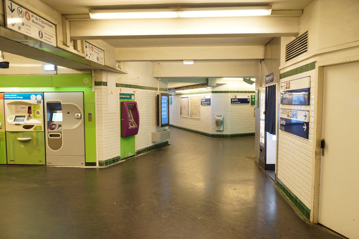 Signage and ticket vending machines inside a Paris Metro Station