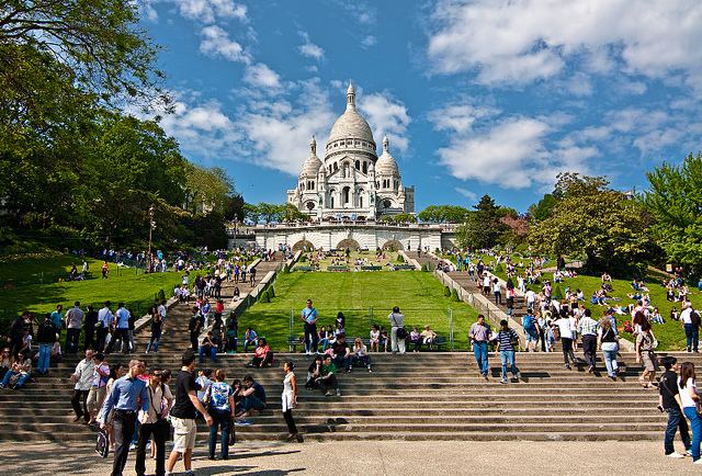 Many people enjoying a gorgeous day on the slopes and stairs leading up to Sacré Coeur