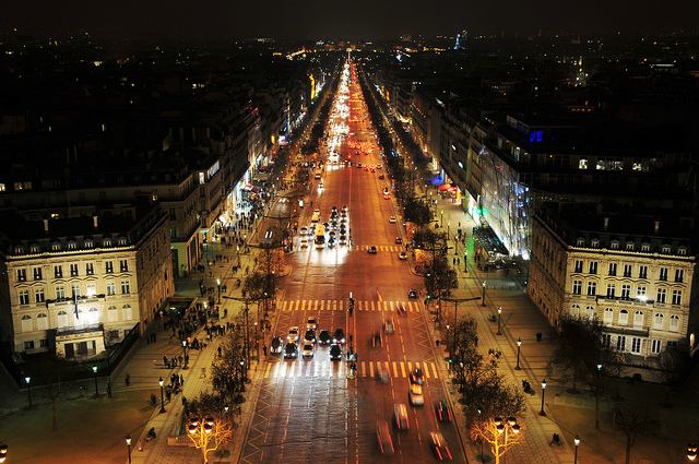 Brightly lit shops along Avenue Champs-Élysées at night